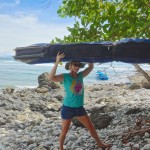 Aloe Driscoll carrying surfboards in Costa Rica.