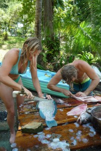 Aloe Driscoll and Leo Ramsey filleting fish.